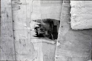 Boy Looking Through A Hole In A Wall