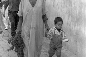A Man & Boy Walking In A Souk 